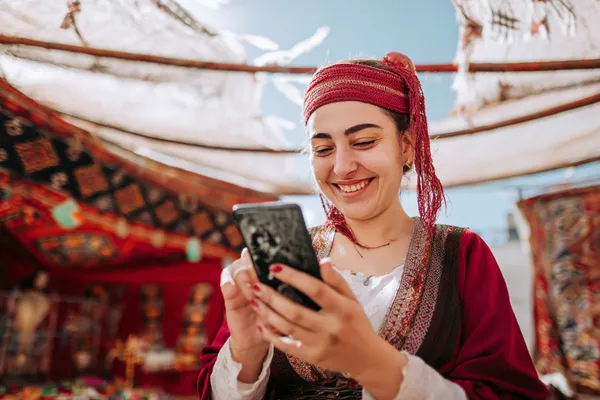 QWE123 Mobile Casino - Chơi ở bất cứ đâu, bất cứ lúc nào Một người chơi sử dụng điện thoại trong khung cảnh sôi động, thể hiện khả năng truy cập di động linh hoạt của QWE123.